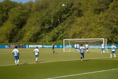 Terrain de football vibrant sous un ciel bleu